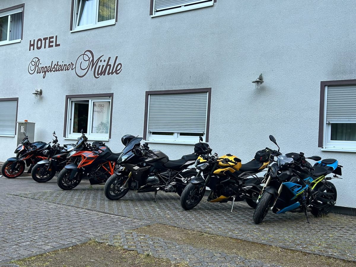 Zes motoren staan op een rij voor de gevel van Hotel Ringelsteiner Mühle.