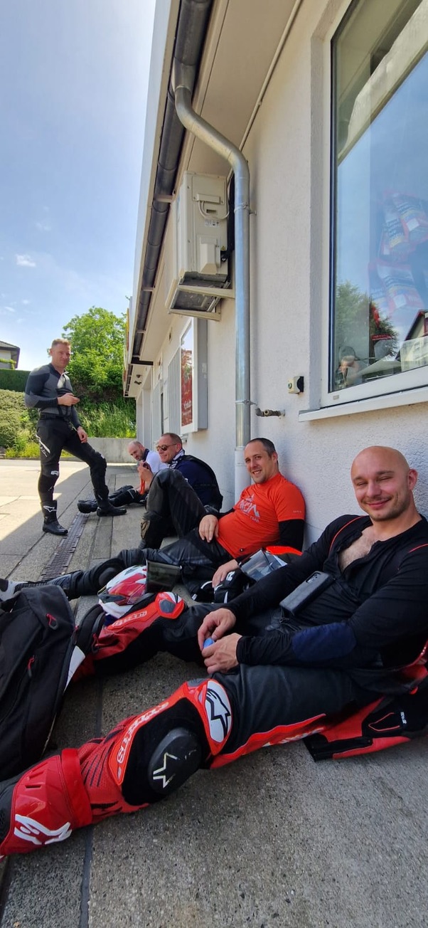 Motorrijders ontspannen tijdens een pauze bij een gebouw.